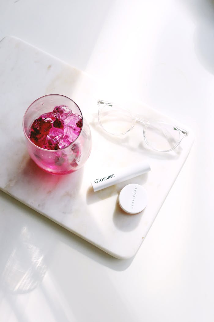our-journey-01 Flat lay of cosmetics with pink drink on marble, perfect for beauty and lifestyle themes.