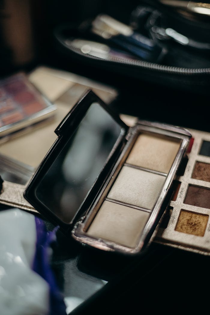 services-03 Open makeup palette with various shades and a mirror, ideal for beauty and cosmetics themes.